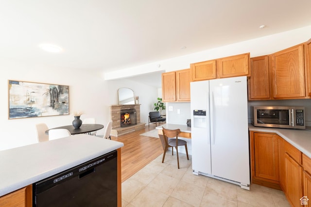 2260 E Murray Holladay Rd S Unit 22, Holladay, UT 84117 - kitchen featuring white refrigerator with ice dispenser, dishwashing machine, stainless steel microwave, light countertops, and a stone fireplace