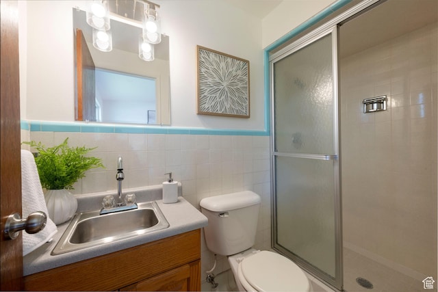 2260 E Murray Holladay Rd S Unit 22, Holladay, UT 84117 - full bath featuring vanity, a shower stall, tile walls, and wainscoting