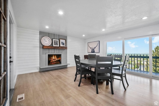 2451 E Cavalier Dr, Cottonwood Heights, UT 84121 - dining area with a large fireplace, wood finished floors, recessed lighting, and a textured ceiling