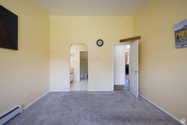 542 W Hale Ave, Moab, UT 84532 - unfurnished bedroom with a baseboard heating unit, arched walkways, carpet floors, and ensuite bath