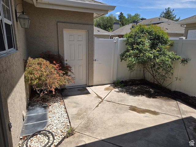 6948 S 855 E, Midvale, UT 84047 - doorway to property featuring stucco siding, a gate, and a patio area