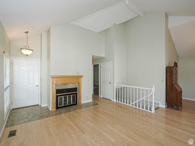 6948 S 855 E, Midvale, UT 84047 - unfurnished living room featuring high vaulted ceiling, light wood-type flooring, a high end fireplace, and beamed ceiling