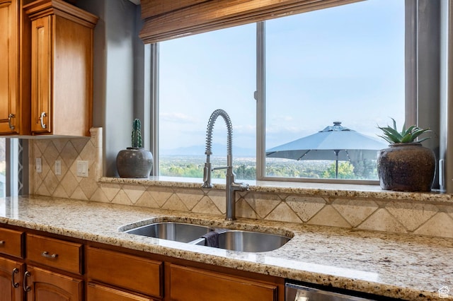 4179 W Sandalwood Dr, Cedar Hills, UT 84062 - kitchen featuring brown cabinetry, tasteful backsplash, and light stone countertops