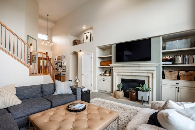 4179 W Sandalwood Dr, Cedar Hills, UT 84062 - living area featuring stairway, a high ceiling, carpet floors, built in features, and a tiled fireplace