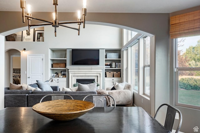 4179 W Sandalwood Dr, Cedar Hills, UT 84062 - living room featuring arched walkways, a chandelier, built in shelves, and a fireplace