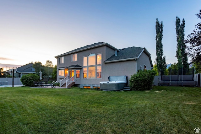 4179 W Sandalwood Dr, Cedar Hills, UT 84062 - back of house at dusk with a patio area, a hot tub, and stucco siding