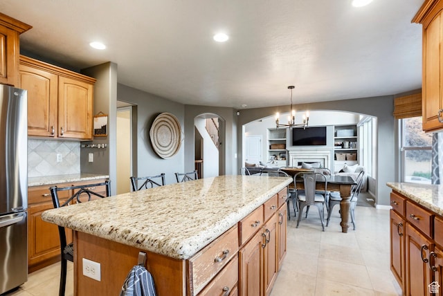 4179 W Sandalwood Dr, Cedar Hills, UT 84062 - kitchen with freestanding refrigerator, arched walkways, recessed lighting, open floor plan, and decorative backsplash