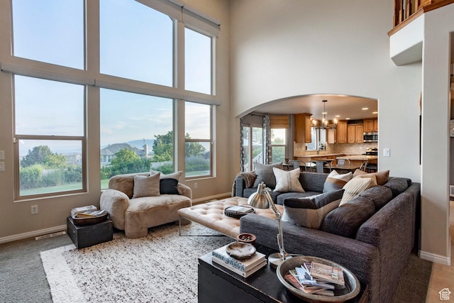 4179 W Sandalwood Dr, Cedar Hills, UT 84062 - living area featuring arched walkways, a chandelier, a high ceiling, a mountain view, and light carpet
