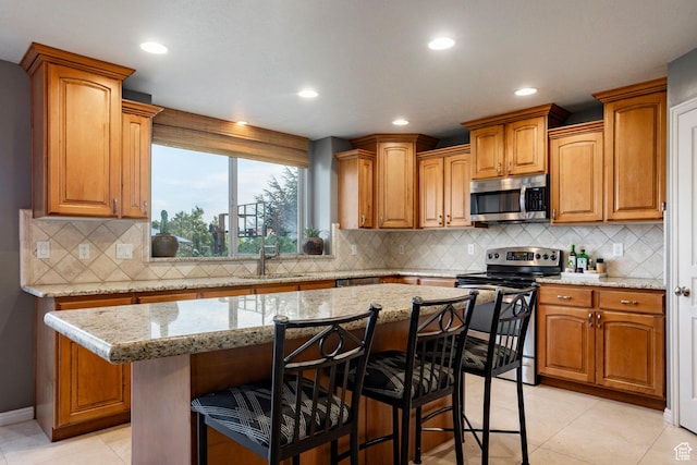 4179 W Sandalwood Dr, Cedar Hills, UT 84062 - kitchen featuring stainless steel appliances, a breakfast bar, recessed lighting, decorative backsplash, and light stone counters
