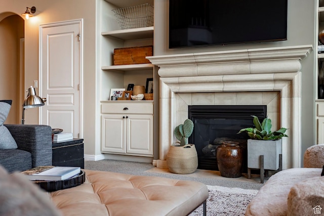 4179 W Sandalwood Dr, Cedar Hills, UT 84062 - living area featuring a fireplace, light colored carpet, built in shelves, and arched walkways