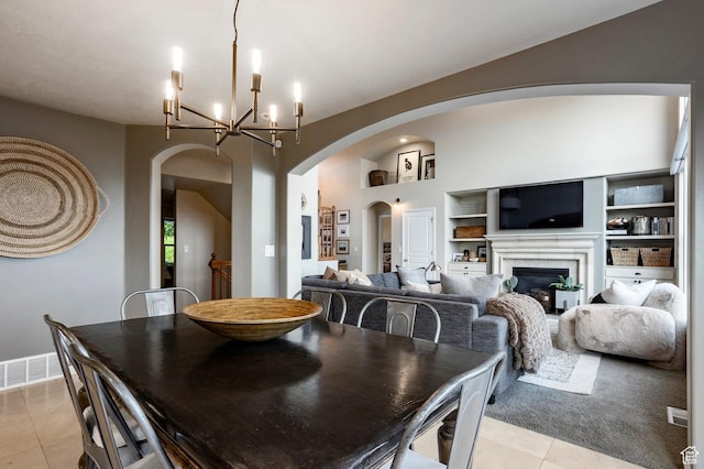 4179 W Sandalwood Dr, Cedar Hills, UT 84062 - dining area with light tile patterned floors, arched walkways, a chandelier, a glass covered fireplace, and built in features