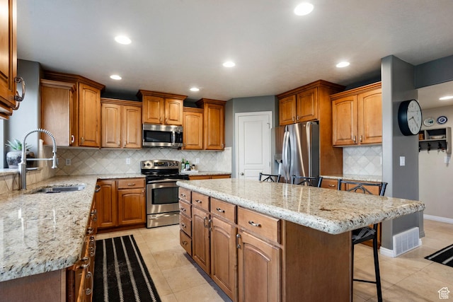 4179 W Sandalwood Dr, Cedar Hills, UT 84062 - kitchen with appliances with stainless steel finishes, a center island, a kitchen bar, backsplash, and brown cabinets