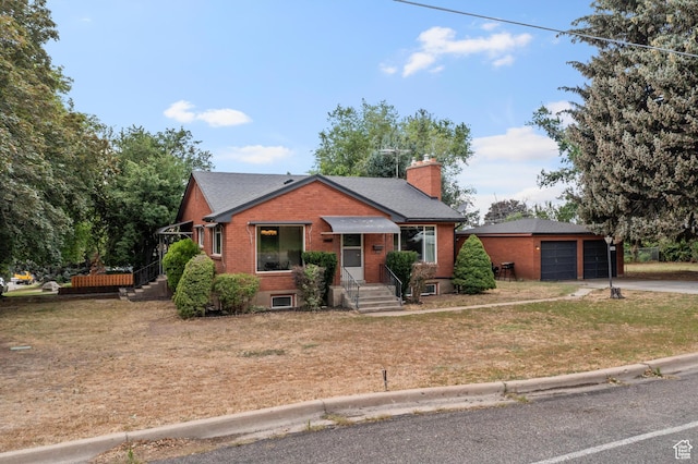 2335 Fillmore Ave, Ogden, UT 84401 - view of front of home with brick siding, driveway, a chimney, and a front yard