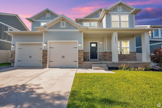 4961 E Oakwood Dr, Eagle Mountain, UT 84005 - craftsman-style house featuring board and batten siding, driveway, stone siding, a front lawn, and a porch