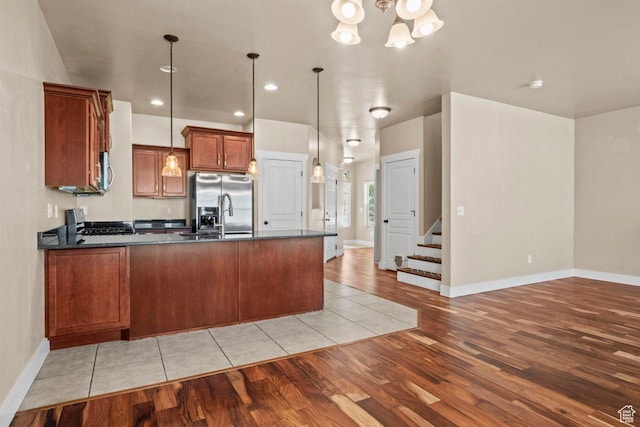 1556 N Venetian Way W, Saratoga Springs, UT 84045 - kitchen with appliances with stainless steel finishes, light wood-style floors, a peninsula, brown cabinetry, and pendant lighting