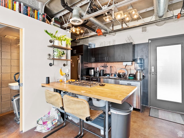 360 W Broadway S Unit 619, Salt Lake City, UT 84101 - kitchen featuring stainless steel appliances, concrete floors, wooden counters, a breakfast bar area, and dark cabinets