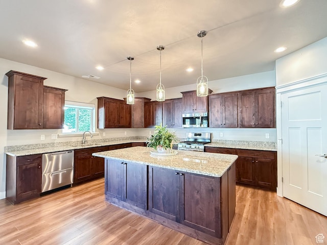 1302 E Mary Ln, Layton, UT 84040 - kitchen featuring appliances with stainless steel finishes, a kitchen island, dark brown cabinetry, light wood-style floors, and recessed lighting