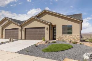 2140 W 320 S Unit 48-51, Hurricane, UT 84737 - view of front facade featuring an attached garage, driveway, stucco siding, and stone siding
