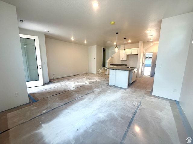 2865 S Ritter Row W Unit 55, West Valley City, UT 84128 - kitchen with dark countertops, white cabinetry, open floor plan, decorative light fixtures, and concrete floors