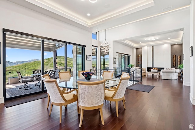 13690 N Deer Canyon Dr, Kamas, UT 84036 - dining area featuring a tray ceiling, a chandelier, a mountain view, and dark wood-type flooring