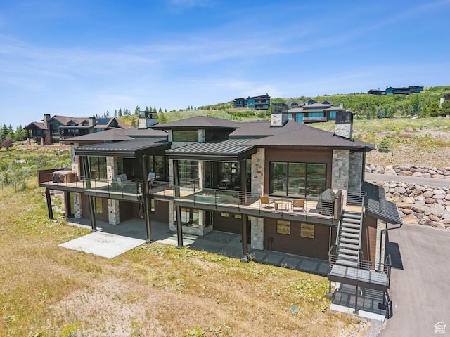 13690 N Deer Canyon Dr, Kamas, UT 84036 - back of house with stone siding, a patio, stairs, and a standing seam roof