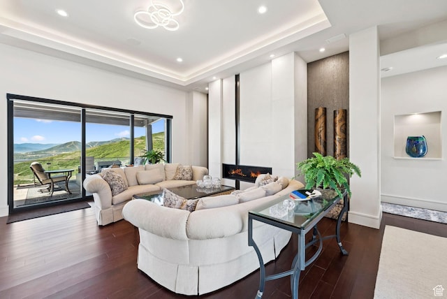 13690 N Deer Canyon Dr, Kamas, UT 84036 - living room with dark wood-type flooring, a glass covered fireplace, recessed lighting, and a tray ceiling
