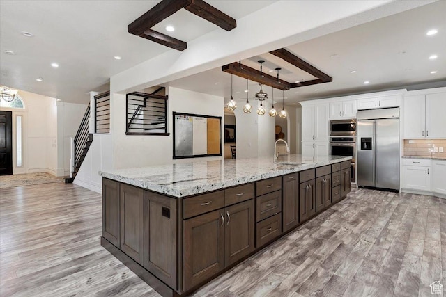 2718 N 2125 E, Layton, UT 84040 - kitchen with built in appliances, light wood-style floors, white cabinetry, dark brown cabinetry, and recessed lighting