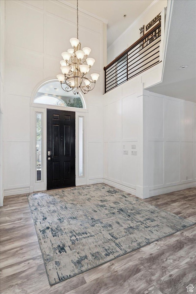 2718 N 2125 E, Layton, UT 84040 - entrance foyer featuring a chandelier, wood finished floors, a decorative wall, ornamental molding, and a high ceiling