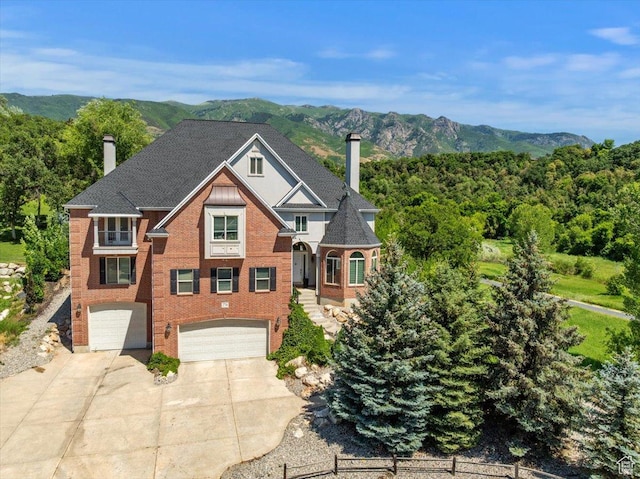 2718 N 2125 E, Layton, UT 84040 - view of front of house with a chimney, driveway, a garage, a mountain view, and brick siding