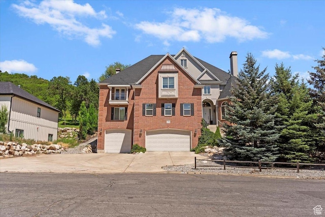 2718 N 2125 E, Layton, UT 84040 - view of front of house with a chimney, an attached garage, driveway, and brick siding
