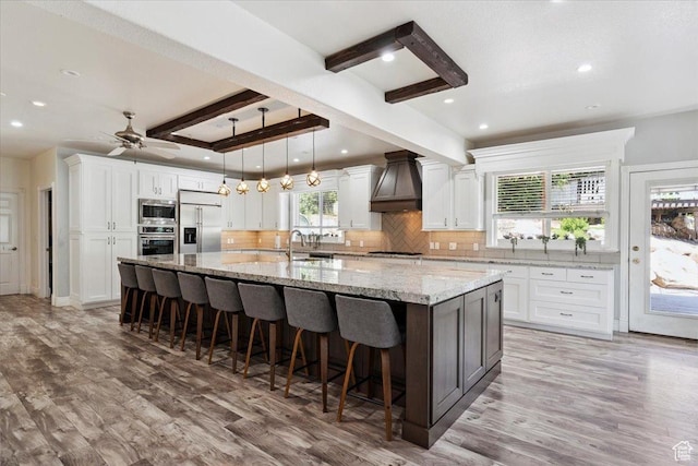 2718 N 2125 E, Layton, UT 84040 - kitchen featuring built in appliances, custom range hood, decorative backsplash, white cabinetry, and beamed ceiling