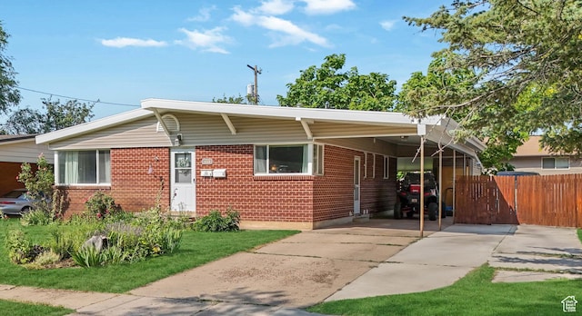 985 Jackson Ave, Ogden, UT 84404 - view of front of home with an attached carport, brick siding, and driveway