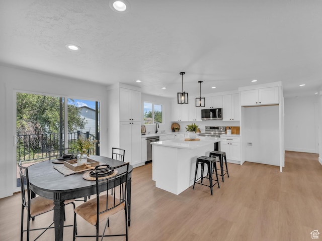 6685 S 3380 W, West Jordan, UT 84084 - kitchen with appliances with stainless steel finishes, light wood-style flooring, recessed lighting, a center island, and white cabinets