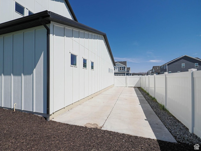928 E Blackfeet Dr, Eagle Mountain, UT 84005 - view of side of home featuring a fenced backyard, board and batten siding, a patio, and a residential view
