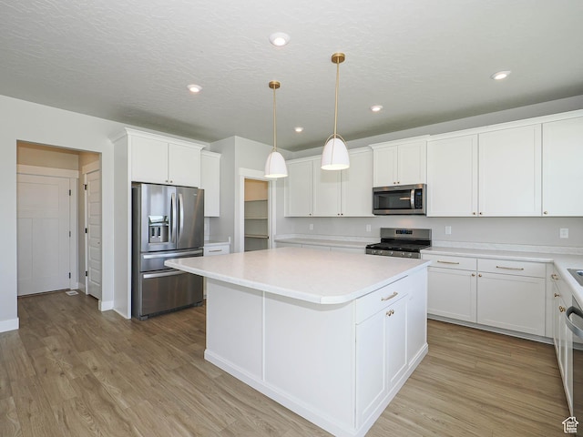 928 E Blackfeet Dr, Eagle Mountain, UT 84005 - kitchen with appliances with stainless steel finishes, a center island, light countertops, white cabinets, and light wood-type flooring