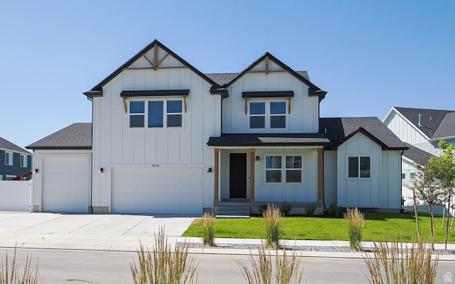 928 E Blackfeet Dr, Eagle Mountain, UT 84005 - view of front of home with board and batten siding, driveway, a front yard, and roof with shingles
