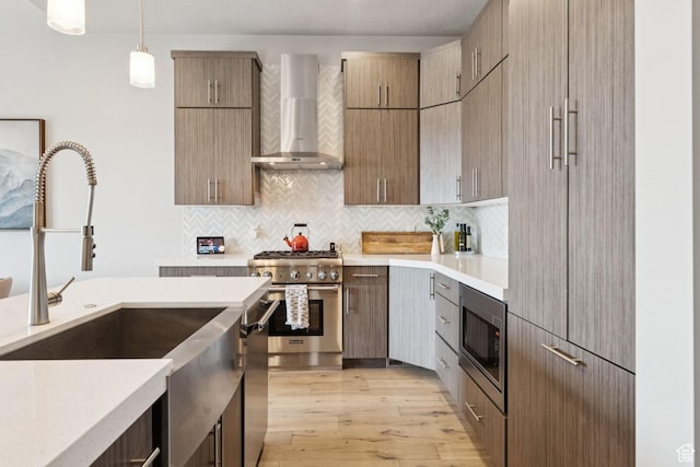 4313 Holly Frost Ct, Park City, UT 84098 - kitchen featuring wall chimney exhaust hood, appliances with stainless steel finishes, light countertops, light wood finished floors, and tasteful backsplash