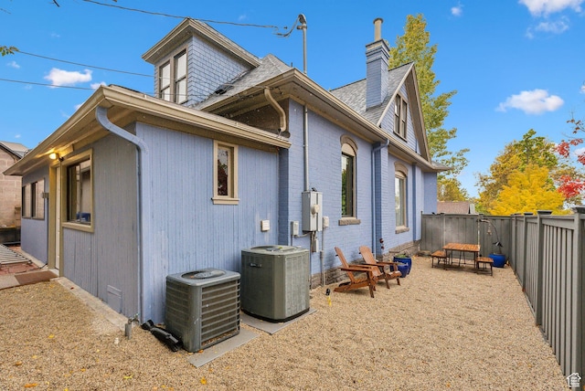 853 E Second Ave N, Salt Lake City, UT 84103 - rear view of property with a chimney, a fenced backyard, a shingled roof, and brick siding