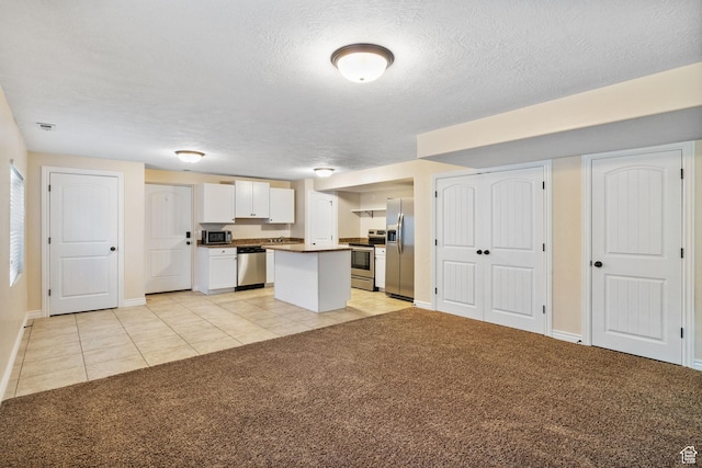 6082 W Cedar Fork Dr S, West Jordan, UT 84081 - kitchen featuring stainless steel appliances, white cabinets, light colored carpet, a kitchen island, and a textured ceiling