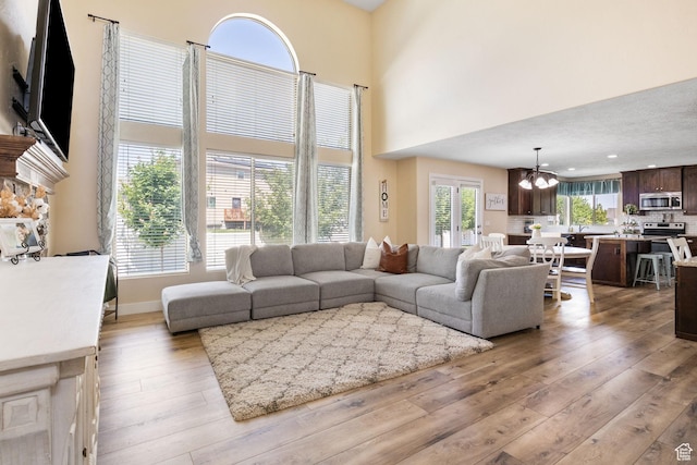 6082 W Cedar Fork Dr S, West Jordan, UT 84081 - living area with hardwood / wood-style floors, a chandelier, a high ceiling, and a fireplace