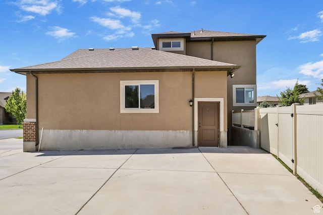 6082 W Cedar Fork Dr S, West Jordan, UT 84081 - rear view of property with a patio area, a shingled roof, and stucco siding