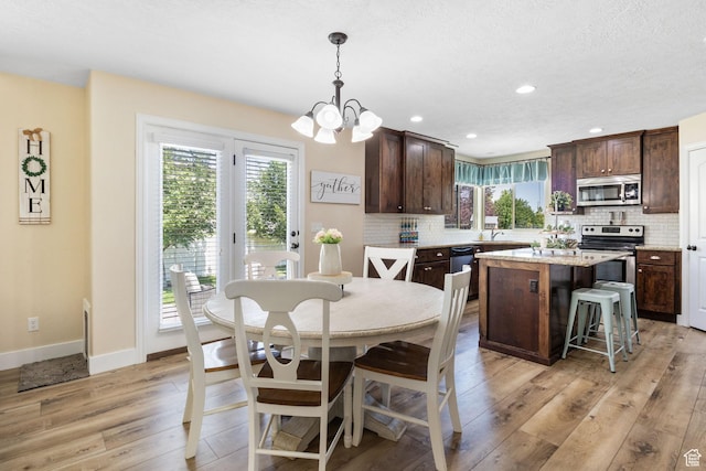 6082 W Cedar Fork Dr S, West Jordan, UT 84081 - dining room with light wood finished floors, a chandelier, and recessed lighting