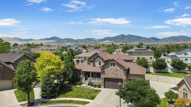 6082 W Cedar Fork Dr S, West Jordan, UT 84081 - view of front of home with a residential view, stone siding, a mountain view, driveway, and a front yard