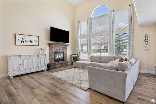 6082 W Cedar Fork Dr S, West Jordan, UT 84081 - living room featuring a towering ceiling, wood finished floors, and a stone fireplace