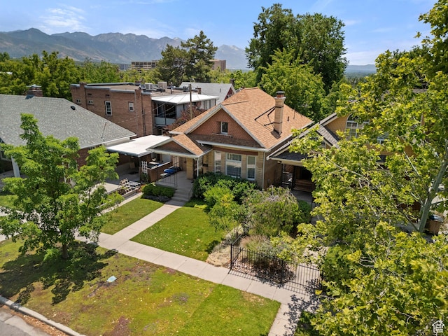 320 E 3rd Ave, Salt Lake City, UT 84103 - view of front of house with a chimney, a mountain view, brick siding, and roof with shingles