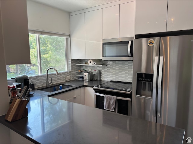 1133 E Sherman Ave S, Salt Lake City, UT 84105 - kitchen featuring stainless steel appliances, dark countertops, white cabinets, and backsplash