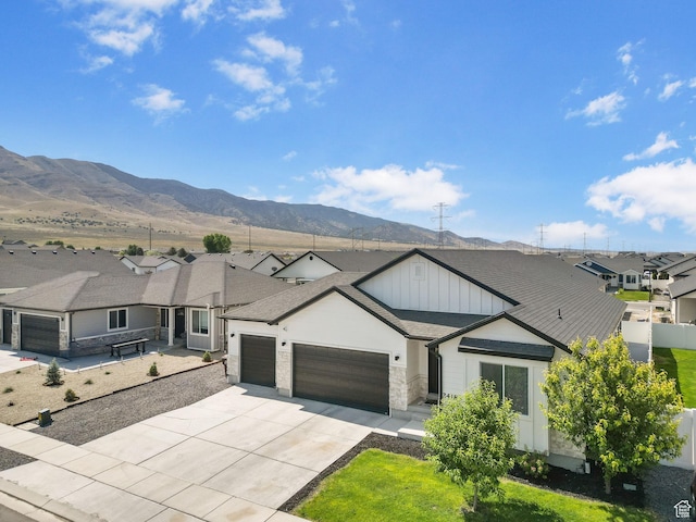 2418 E Quaking Aspen Ln, Eagle Mountain, UT 84005 - view of front facade featuring a garage, board and batten siding, a residential view, concrete driveway, and a mountain view