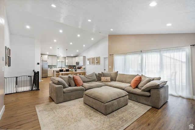 2418 E Quaking Aspen Ln, Eagle Mountain, UT 84005 - living area featuring wood finished floors, high vaulted ceiling, and recessed lighting