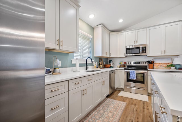 2418 E Quaking Aspen Ln, Eagle Mountain, UT 84005 - kitchen featuring stainless steel appliances, light wood-style floors, vaulted ceiling, light countertops, and recessed lighting