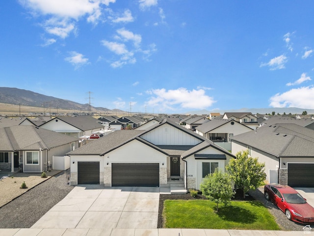 2418 E Quaking Aspen Ln, Eagle Mountain, UT 84005 - view of front of house featuring a residential view, a garage, concrete driveway, a mountain view, and board and batten siding